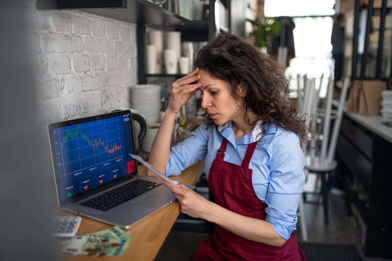 A small business owner reviewing website analytics on a laptop while noticing low phone inquiries or missed conversions.