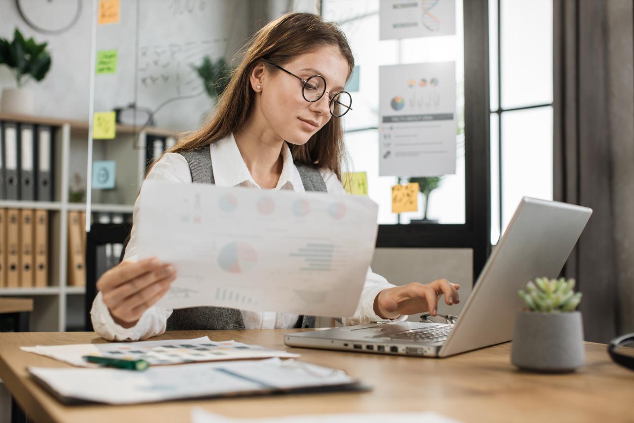 A small business owner reviewing website costs on a laptop with a simple budget chart or maintenance checklist.